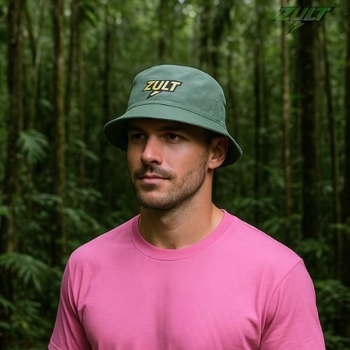 Bob vert ZULT #3 Collection Signature avec logo brodé, porté en pleine nature tropicale par un homme en t-shirt rose, style outdoor et urbain.