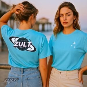 T-shirts bleus ZULT ORBIT #2 Collection SIGNATURE portés par deux femmes au bord de la mer, design spatial avec planète et étoiles, style futuriste et lifestyle estival.